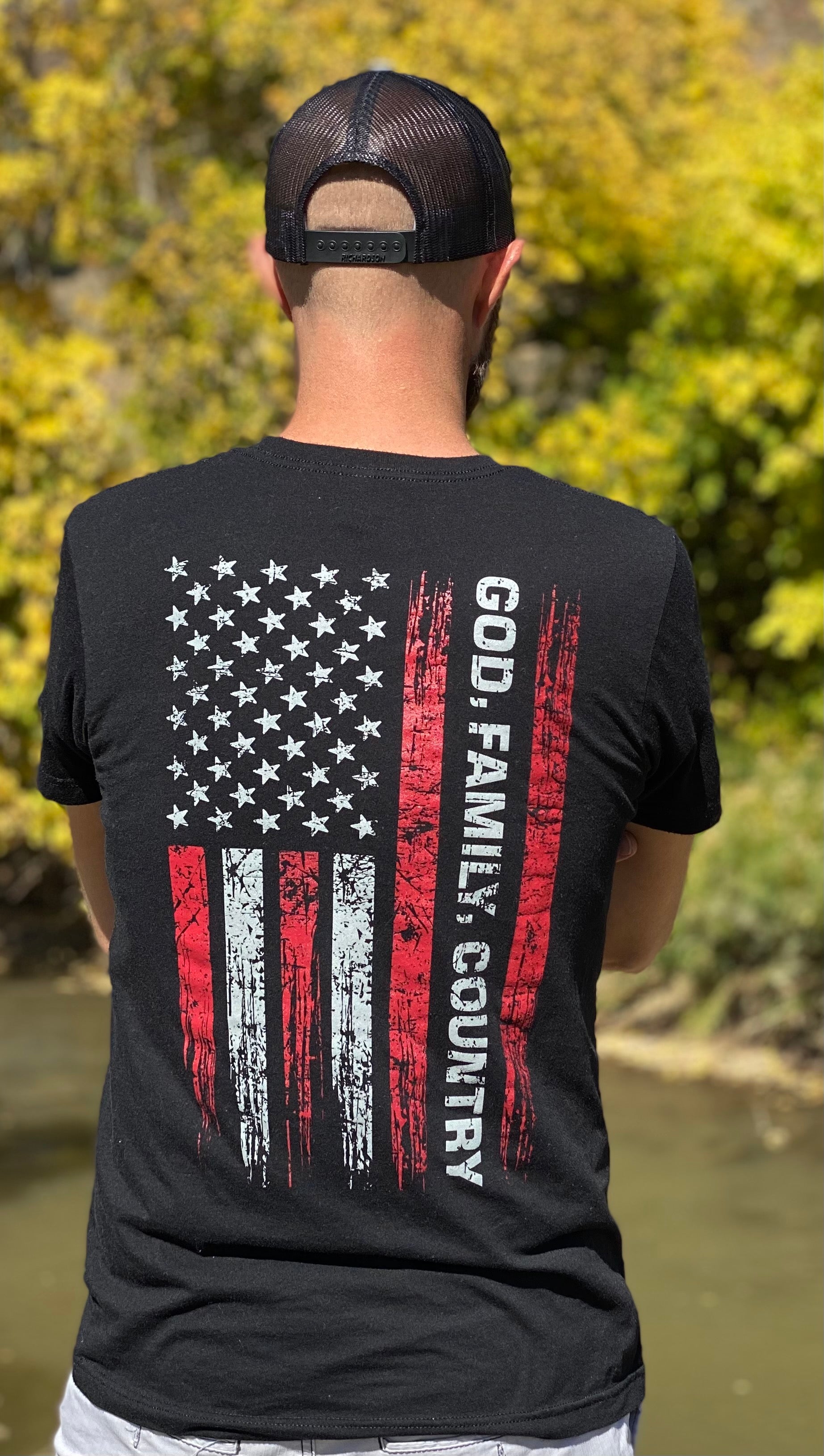 Man wearing God, Family, Country shirt. Has the US Flag with God, Family, Country in bold text.