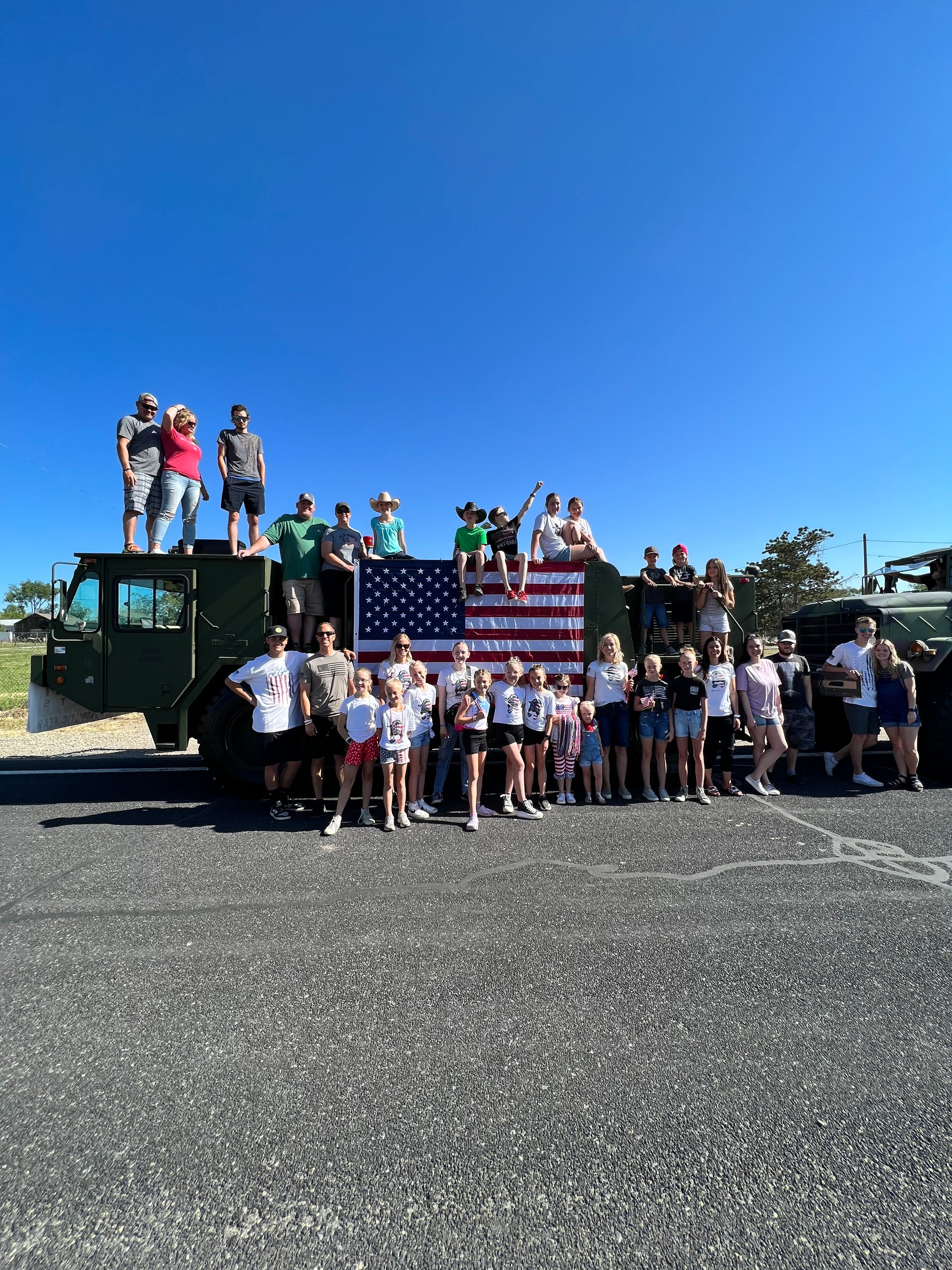 Picture of parade participants in Herriman Utah celebrating freeedom in front of large military truck