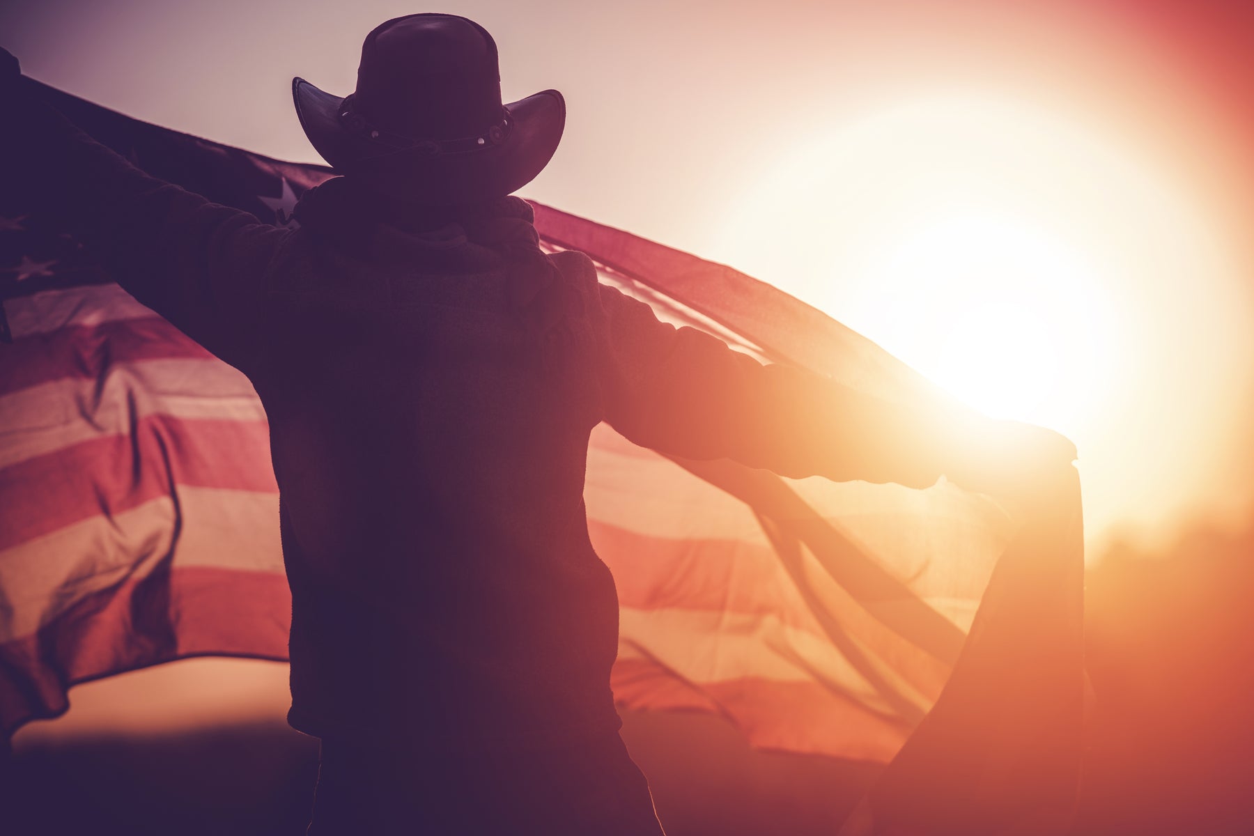 Cowboy celebrating independence day with a flag on a horse